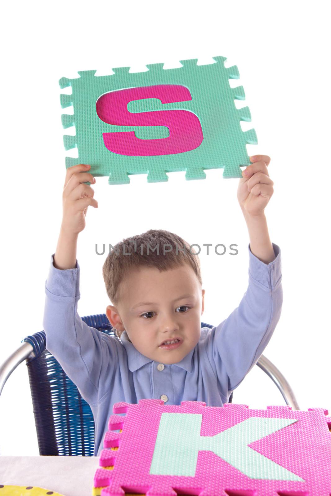 Boy with colorful letters in raised hands, isolated on white