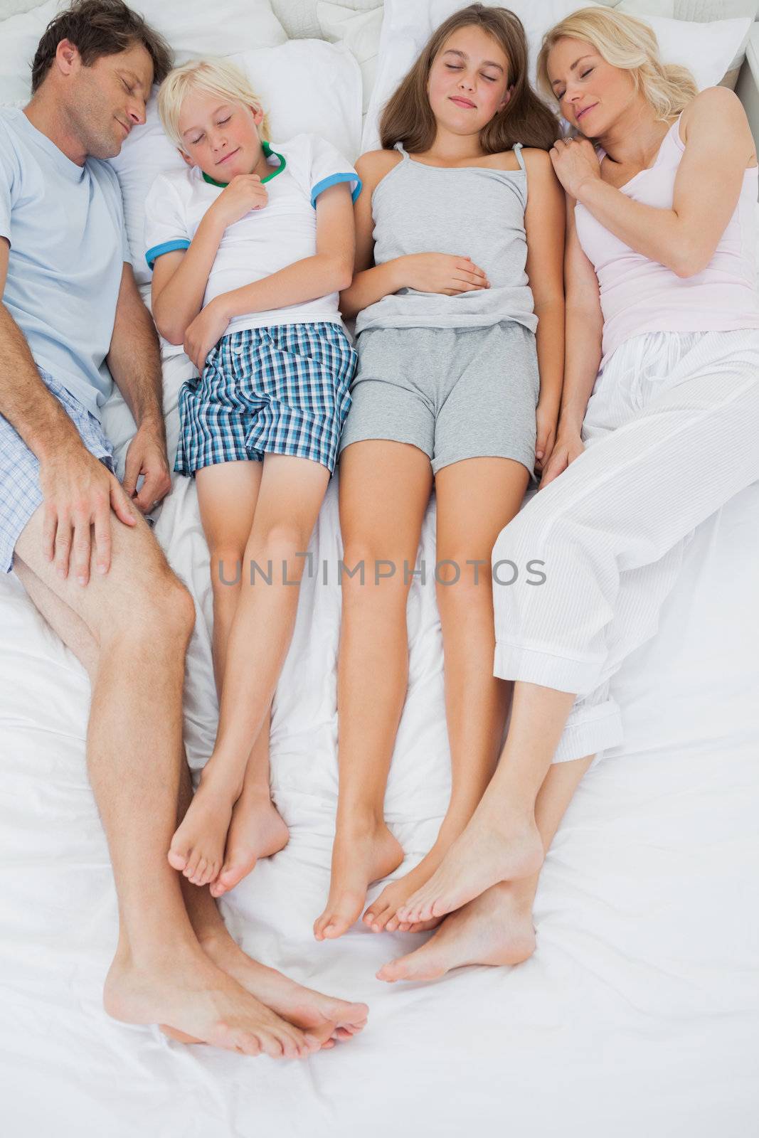 Family sleeping in bed together