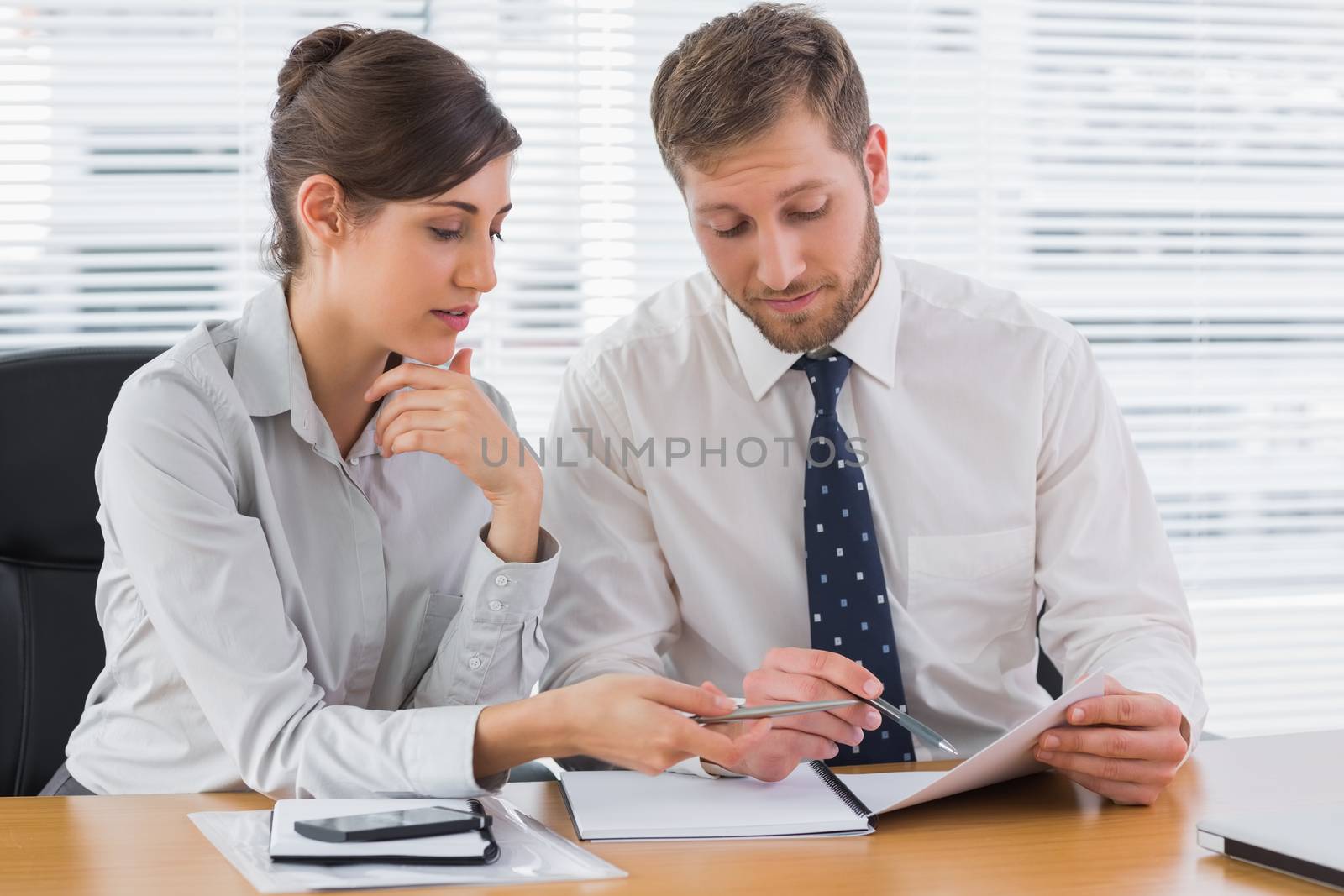 Business people going over documents at desk in office