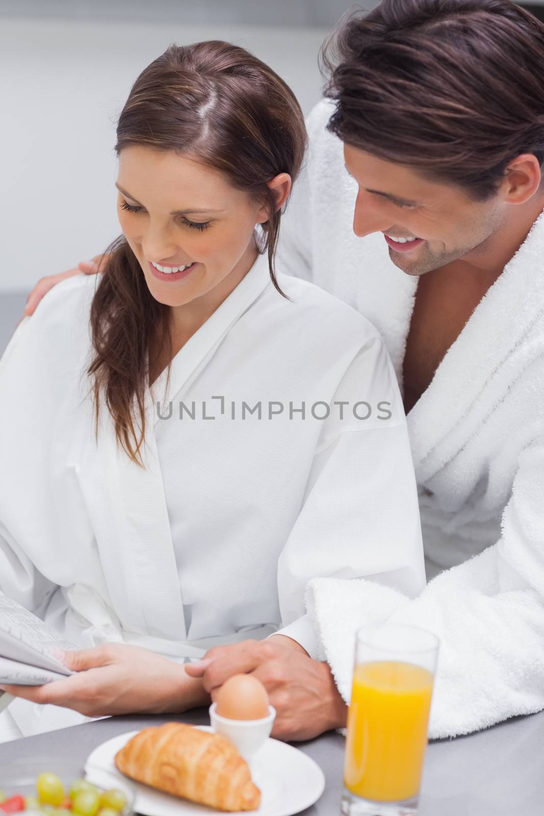 Delighted couple having breakfast in kitchen