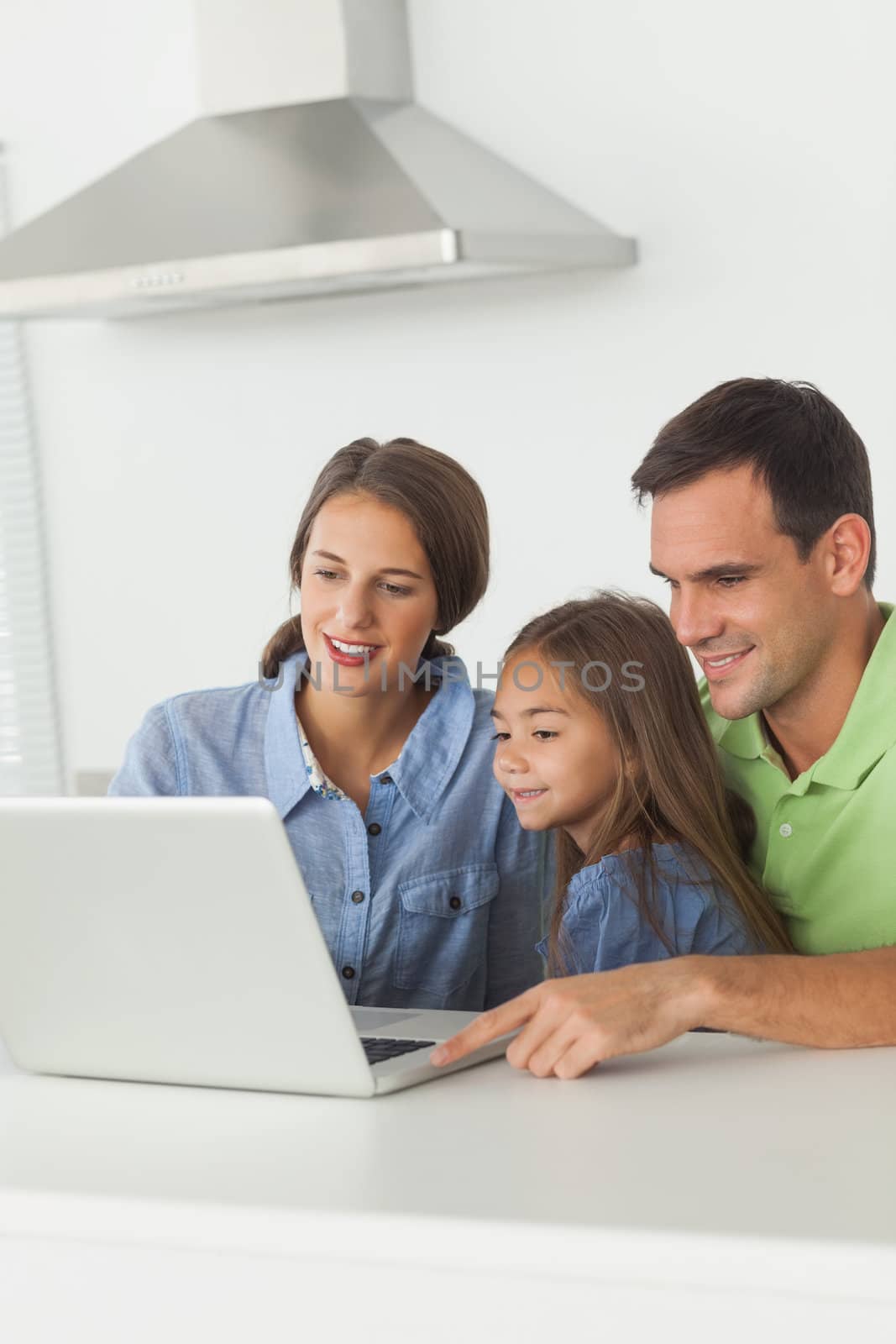 Beautiful family using a laptop pc on the kitchen table
