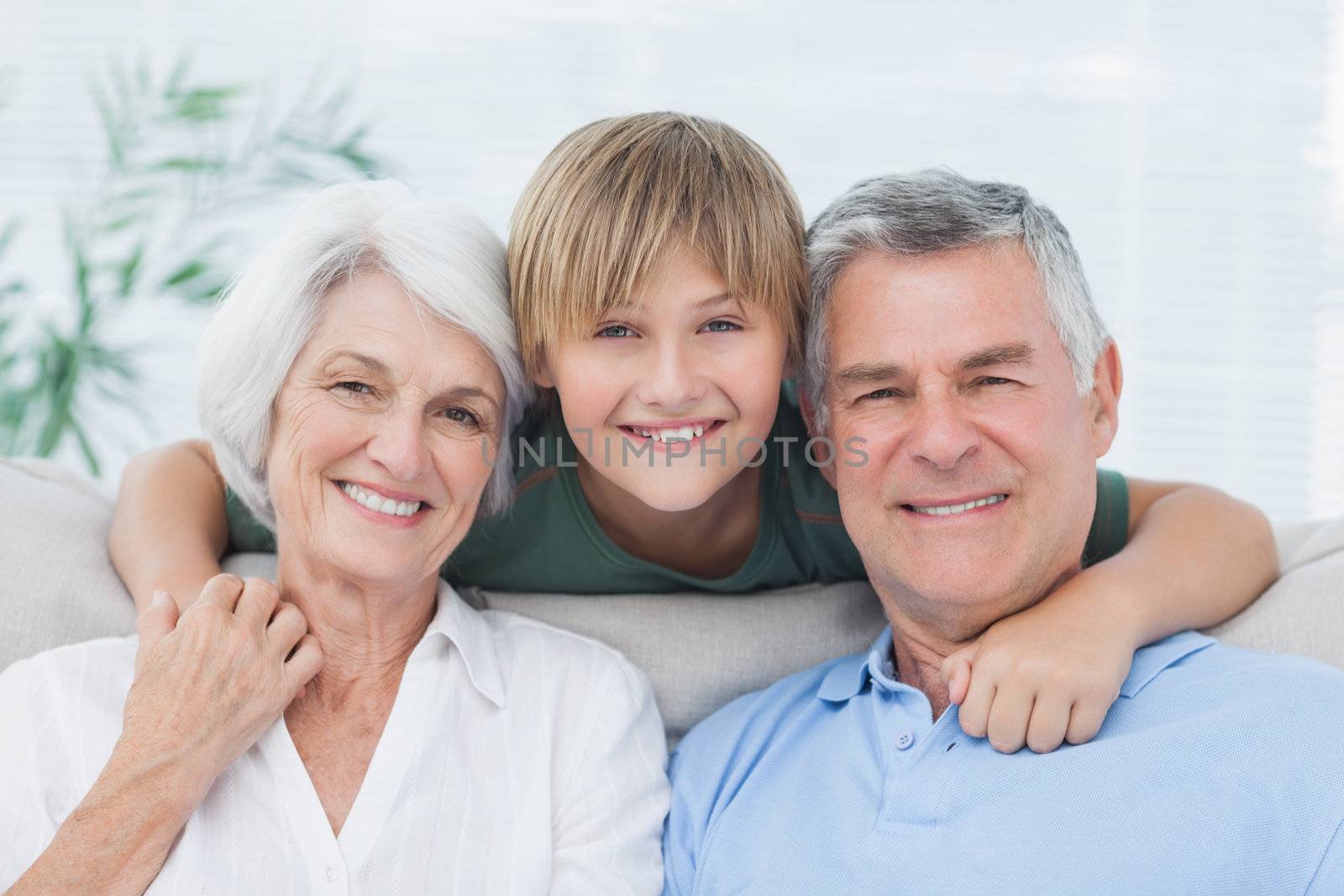 Grandson embracing his grandparents in living room