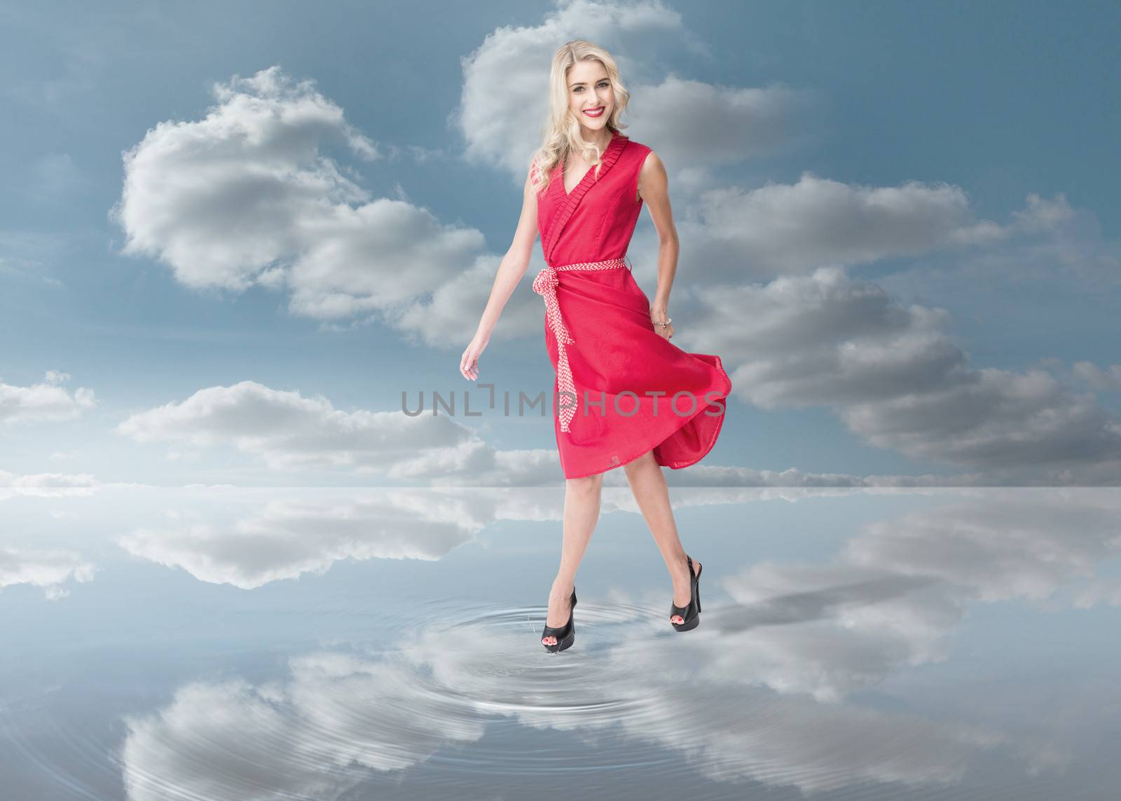 Fashion woman wearing a red dress and walking on a puddle