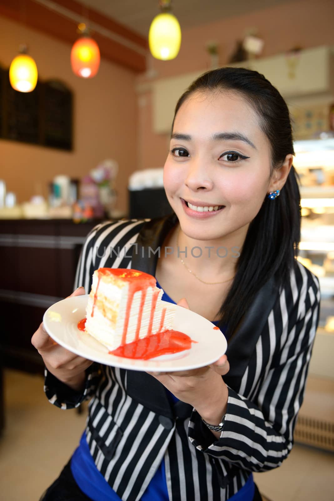 The beautiful smiling asian young woman with a cake