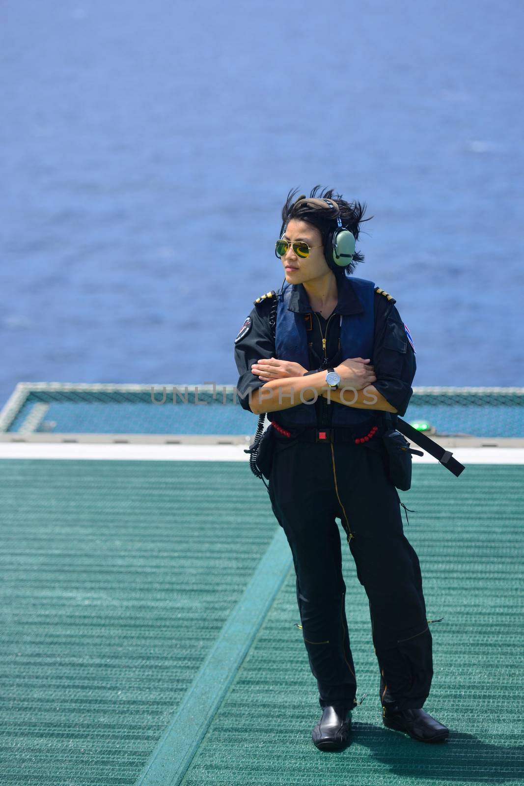 asian woman offshore helicopter pilot is standing on offshore oil rig