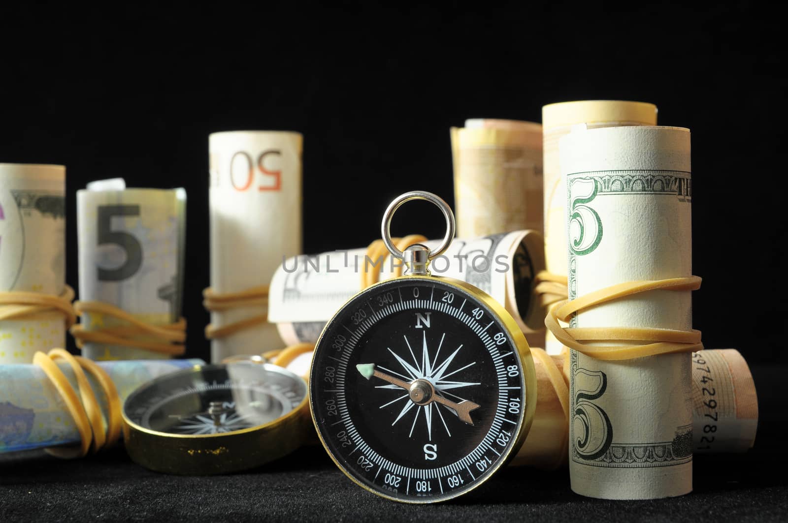 Orientation in  Business Compass and Money on a Black Background