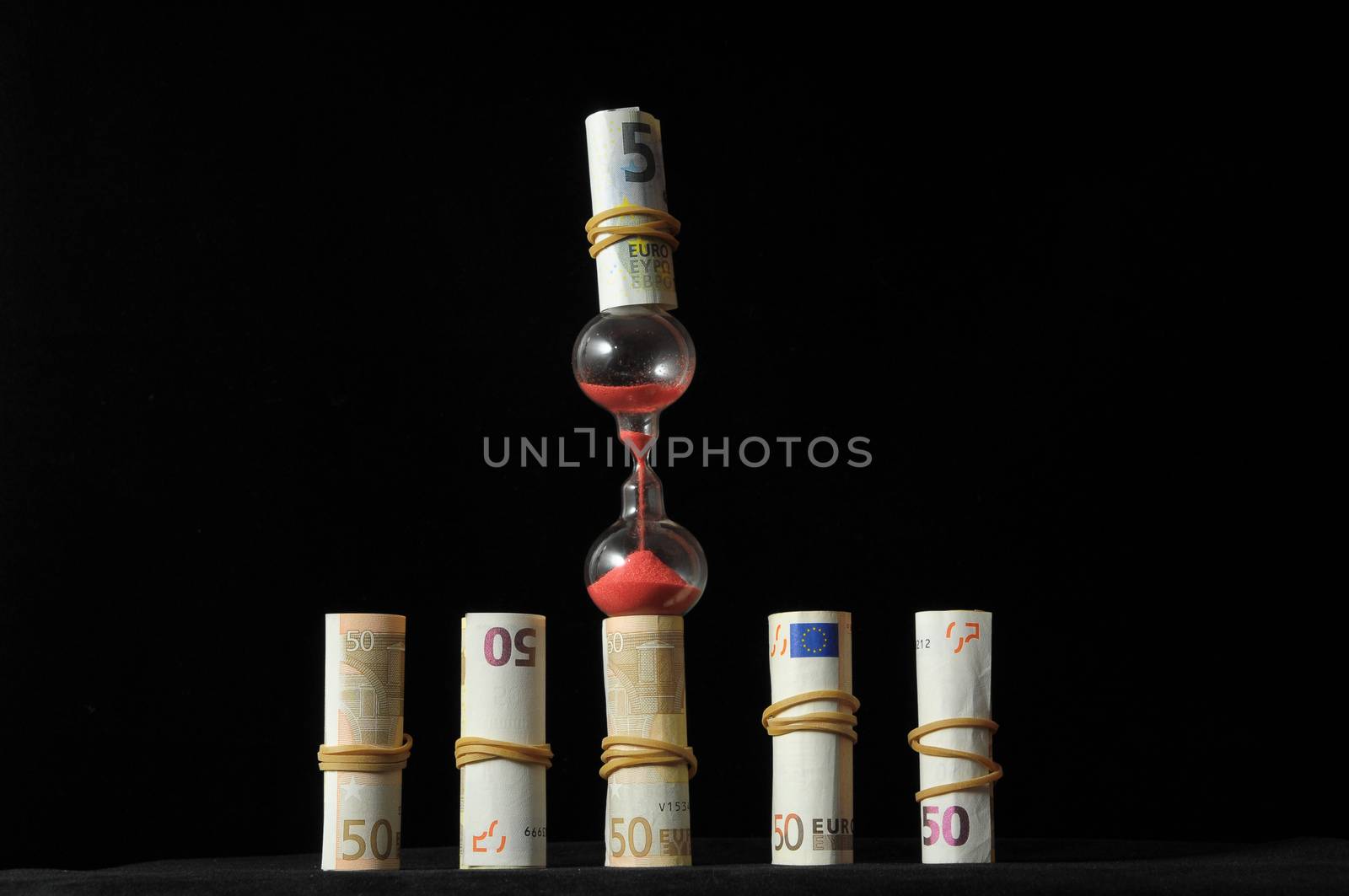 Business Time Concept Money and Hourglass on a Black Background