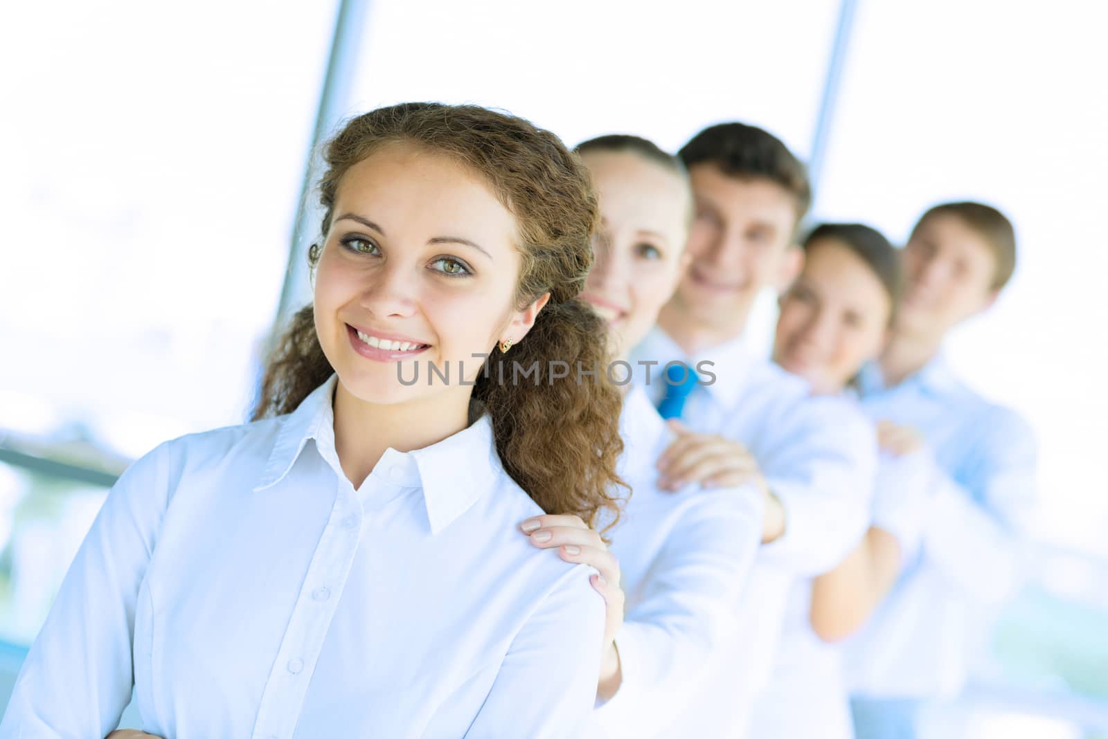 portrait of a young business woman standing in line with colleagues, concept of teamwork