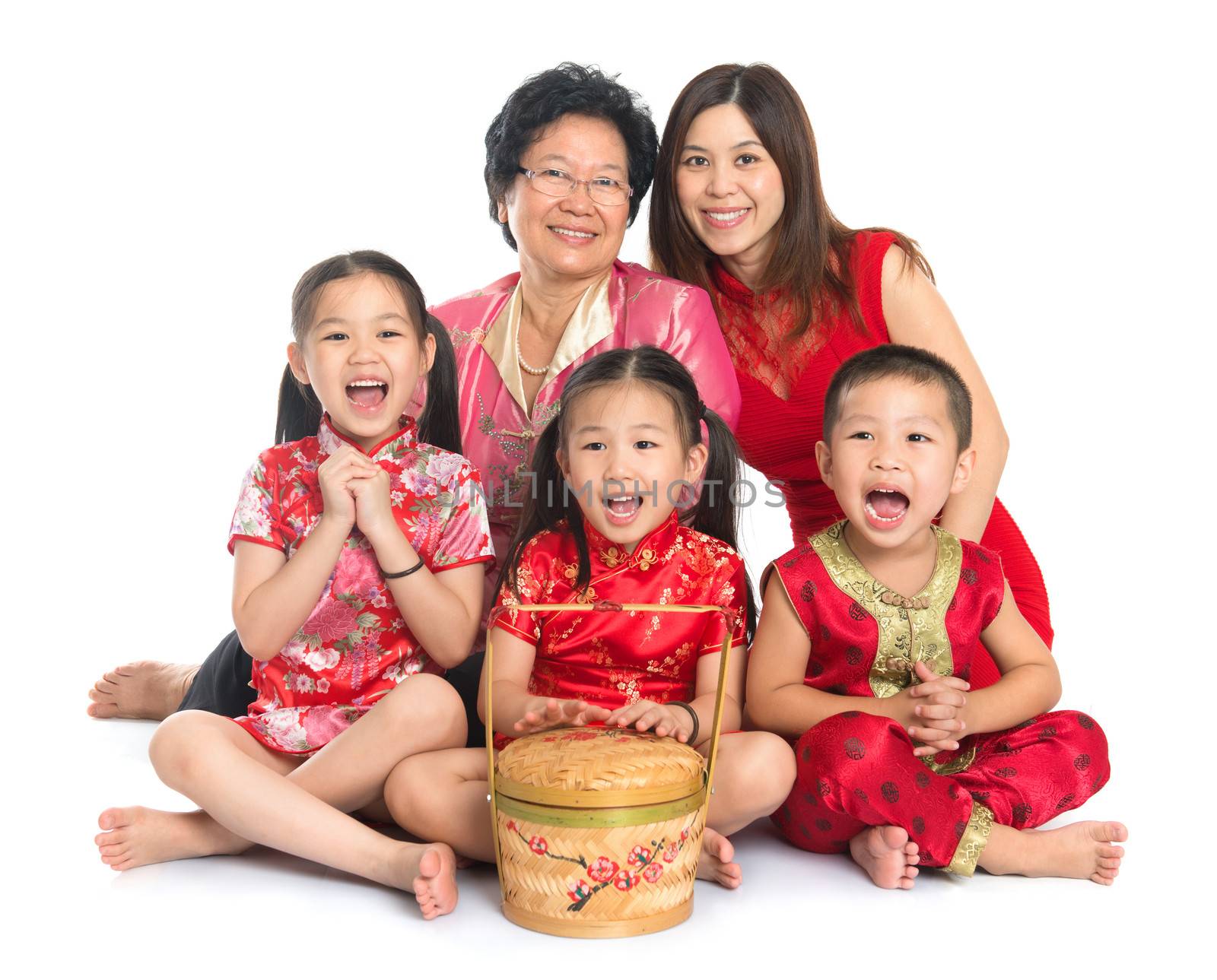 Group of happy multi generations Asian Chinese family wishing you a happy Chinese New Year, with traditional Cheongsam sitting isolated on white background.