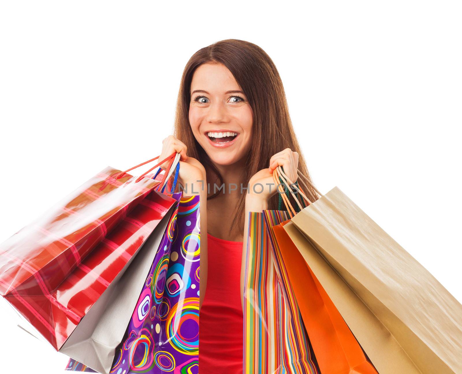Portrait of a young woman holding shopping bags and looking very happy, isolated on white