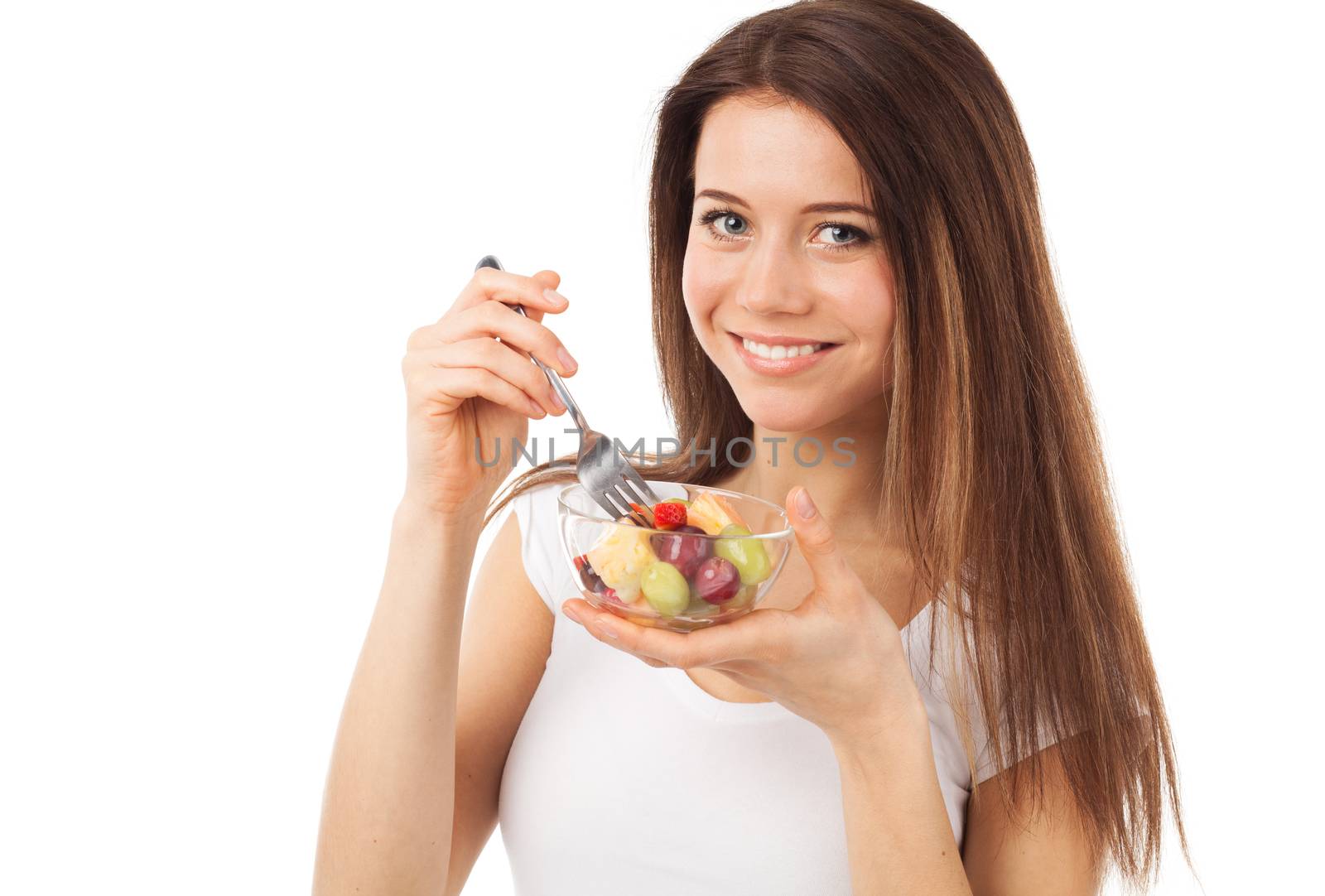 Nice young woman eating fruits and smiling, isolated on white