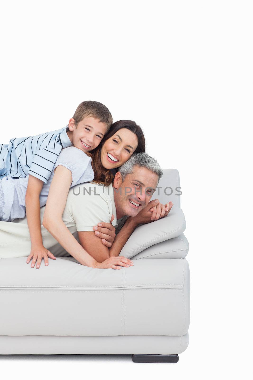 Little boy lying on his parents on sofa on white background