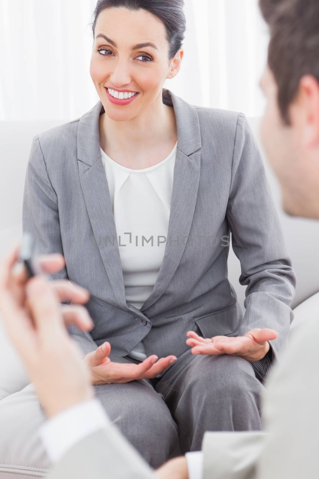 Cheerful coworkers talking sitting on sofa by Wavebreakmedia