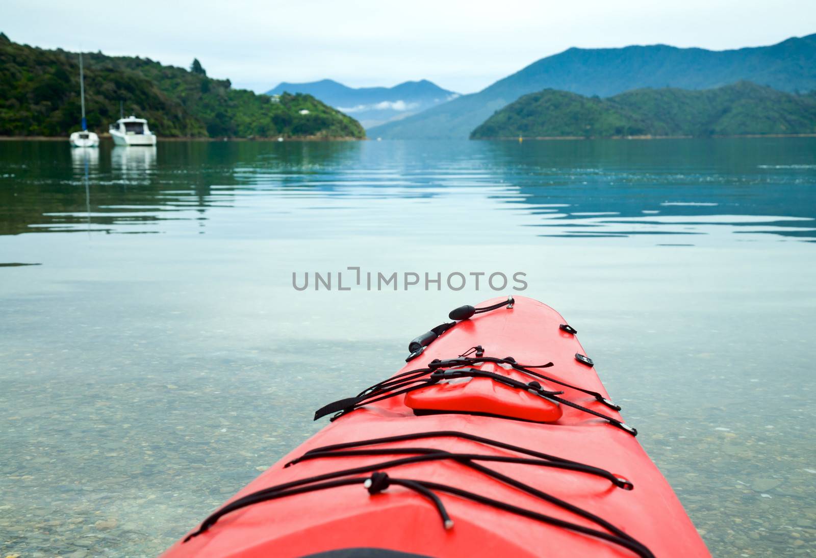 Red touring kayak in waters of the Marlborough Sounds, New Zealand