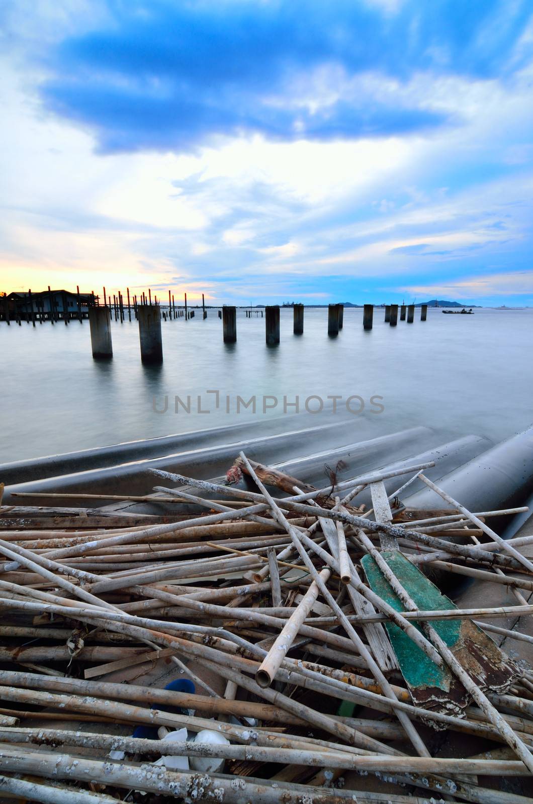 Sunset sky with bridge column in the sea by pixbox77