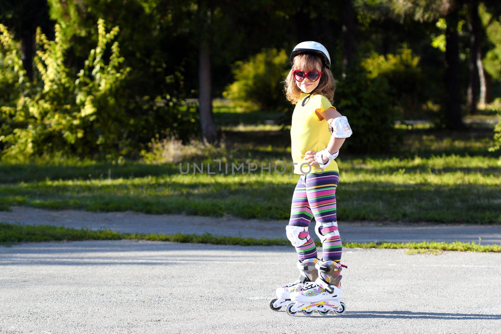 little girl with roller skates and protective equipment