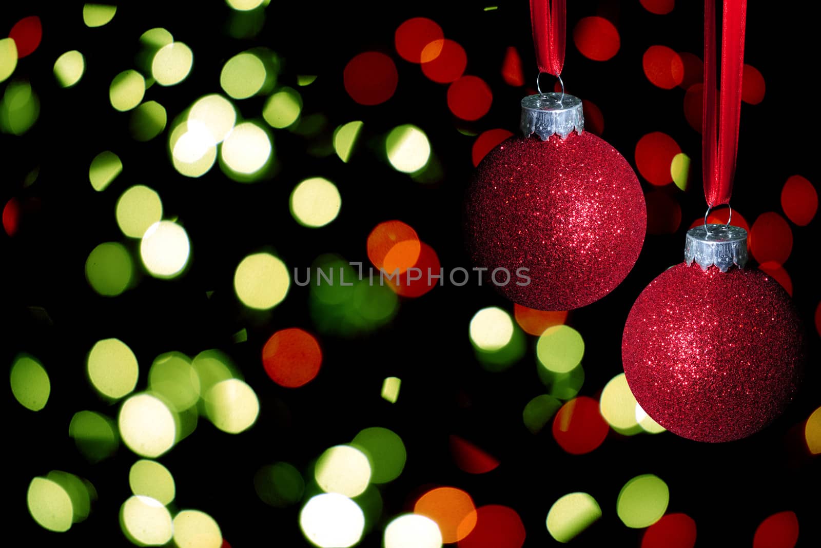 red christmas balls with glitter on abstract lights background