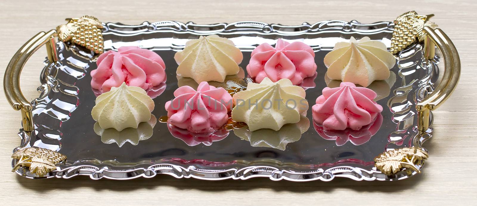 Yellow and pink meringues on a tray
