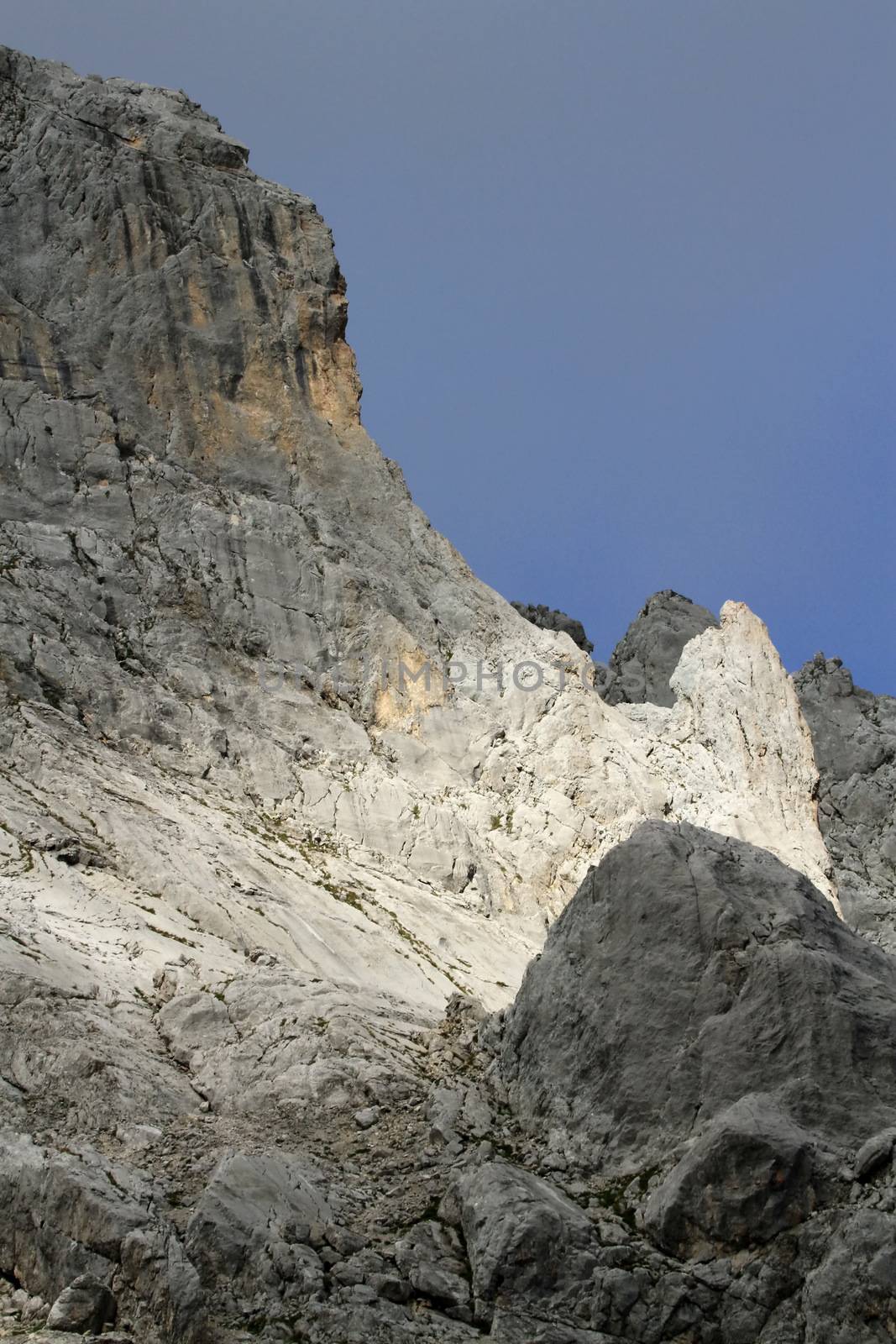 Beautiful sunlight on grey Alps rock by cloudy weather