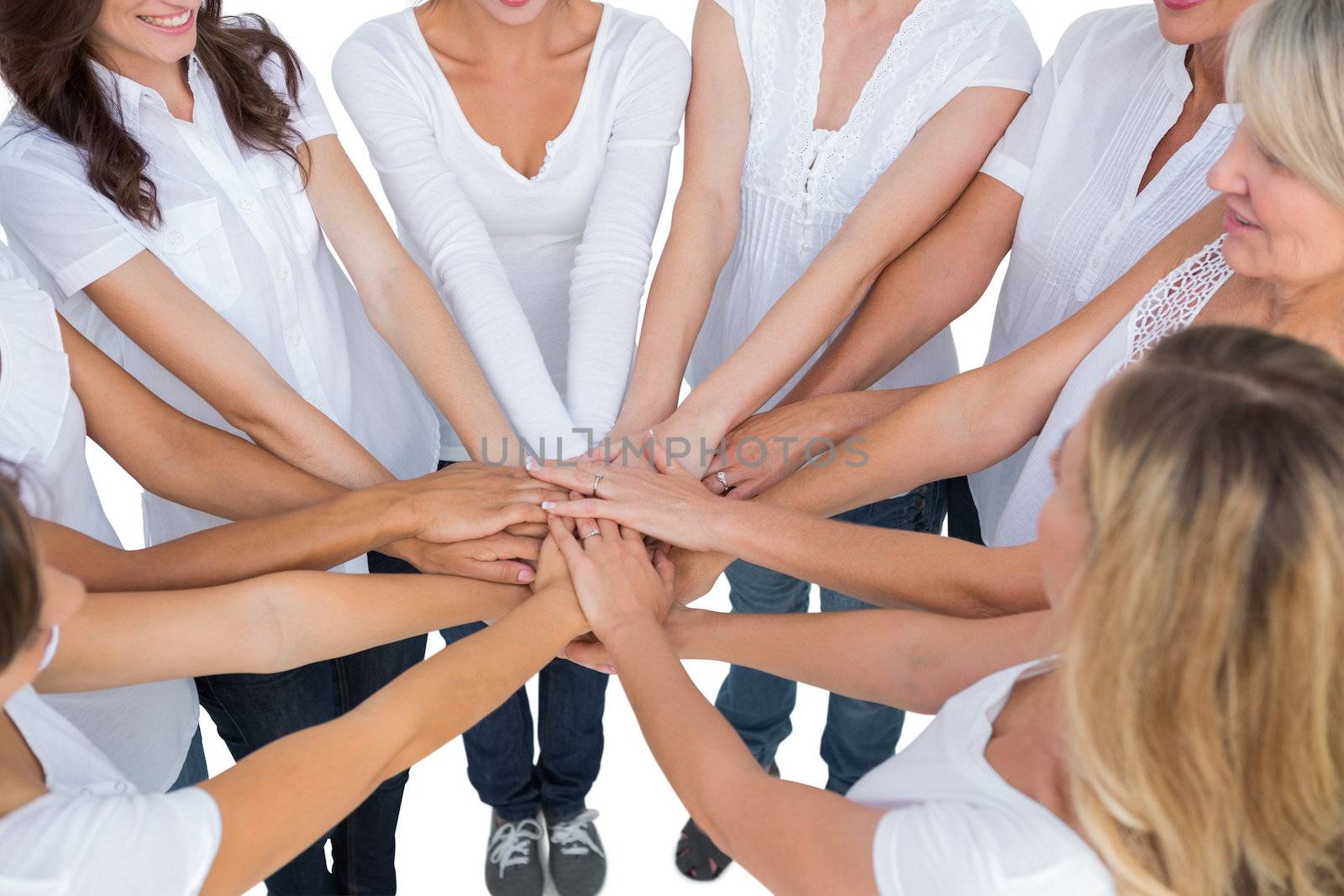 Female models joining hands in a circle on white background