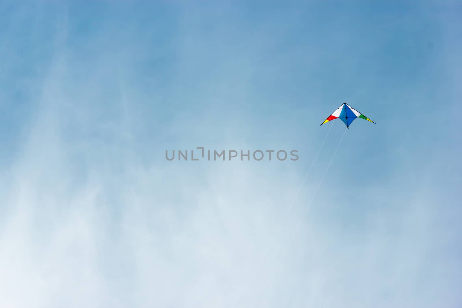colorful kite flying in a nice blue sky by Tetyana