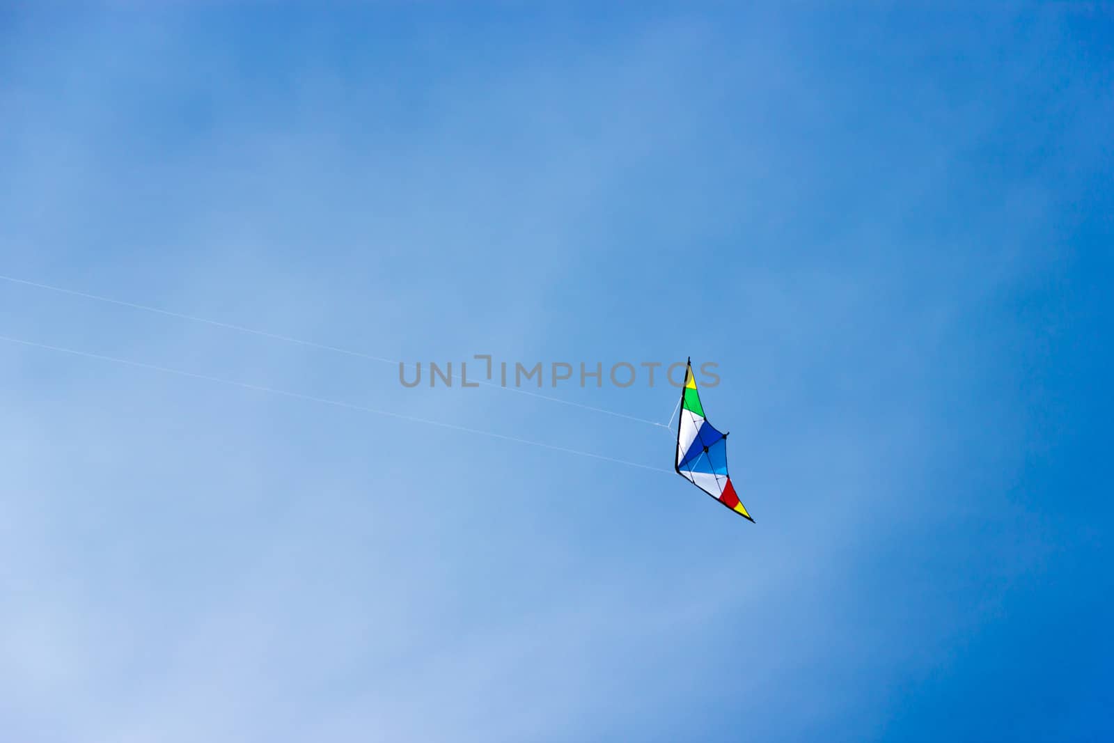 colorful kite soaring in a nice blue sky by Tetyana