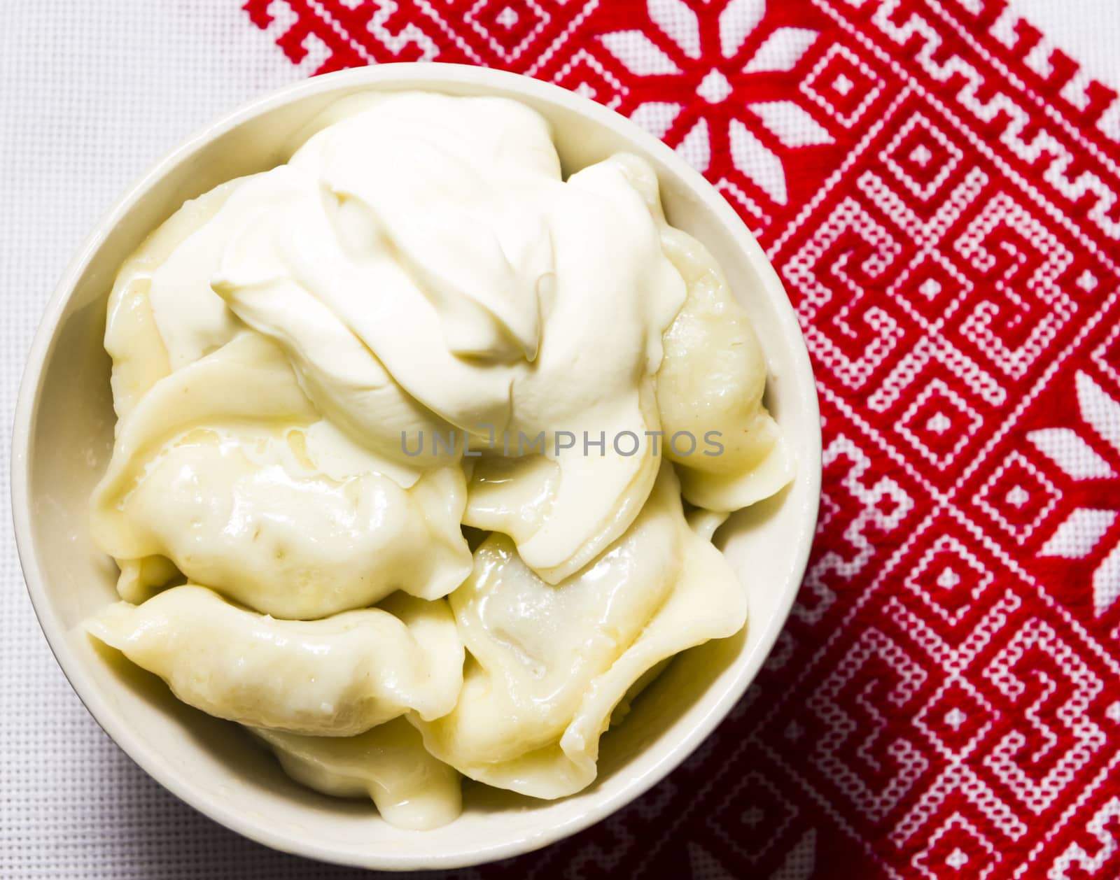 Dumplings with sour cream on the Ukrainian embroidered towel by Tetyana