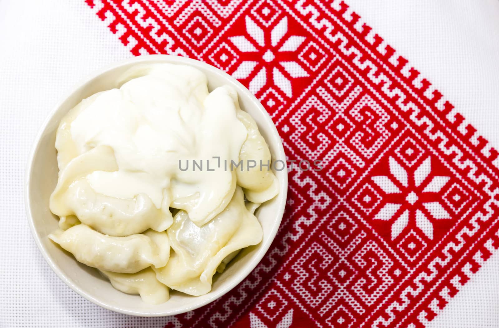 Dumplings with sour cream on the Ukrainian embroidered towel by Tetyana