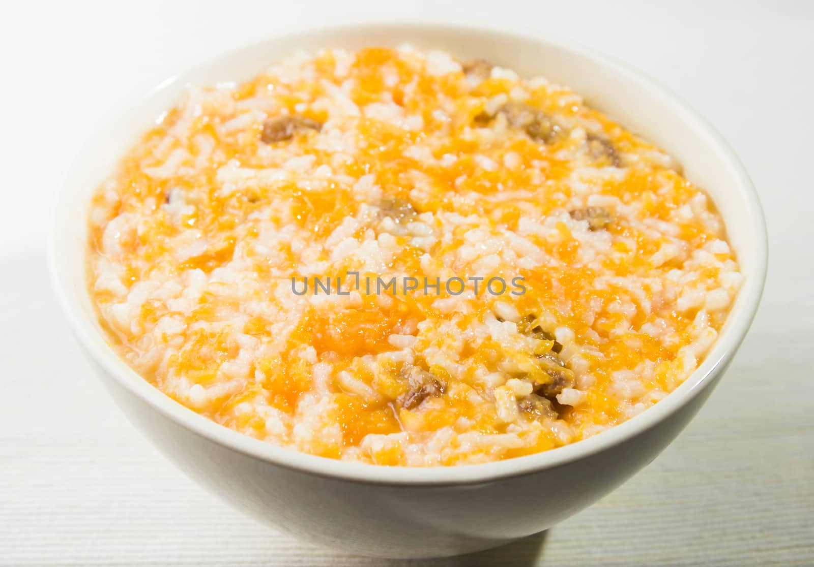 pumpkin rice porridge with raisins in a bowl