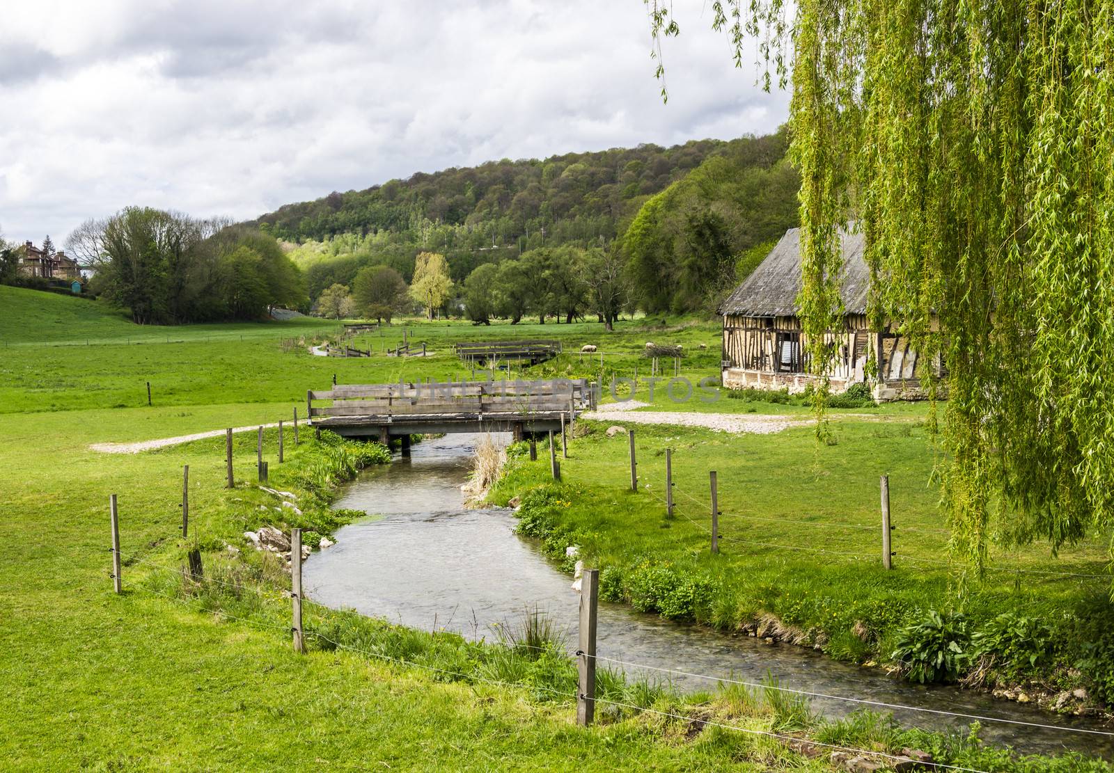 Scenic view on the french spring countryside with river and bridge by Tetyana