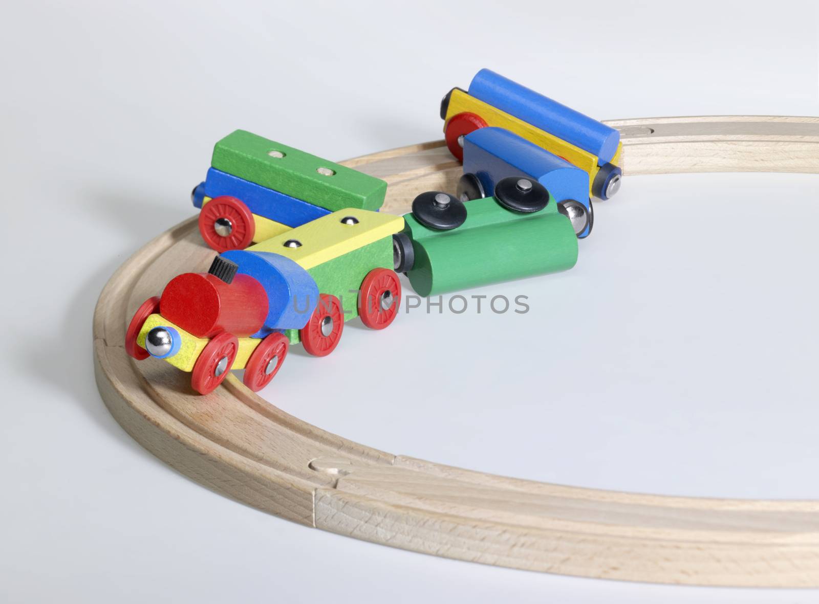 studio photography of a colorful wooden toy train and tracks while a accident happened, in light back