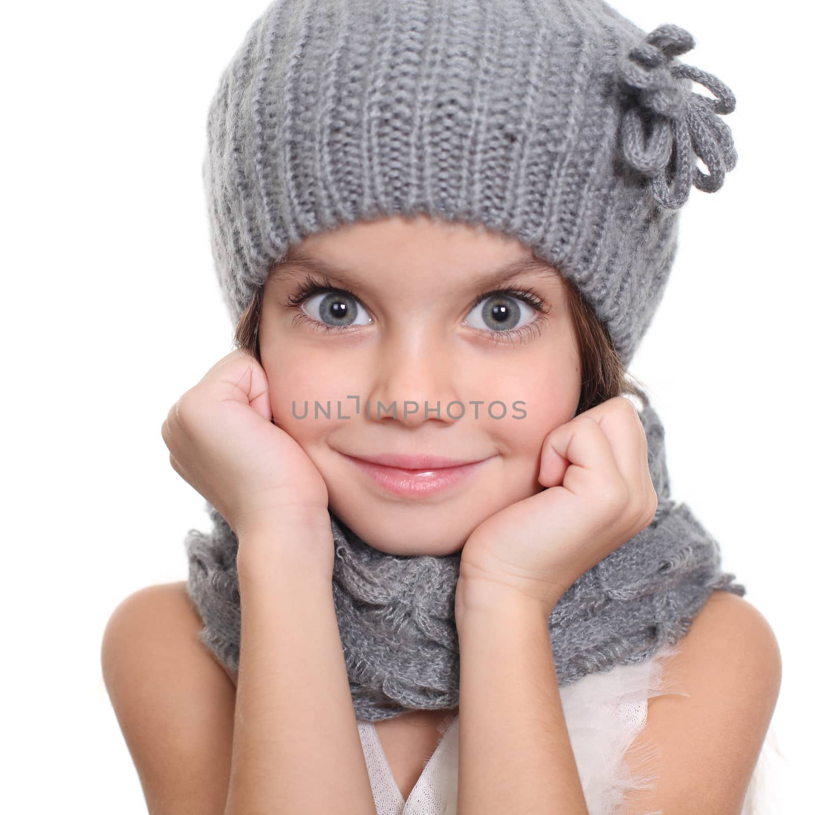 little girl in a knitted hat and gray scarf