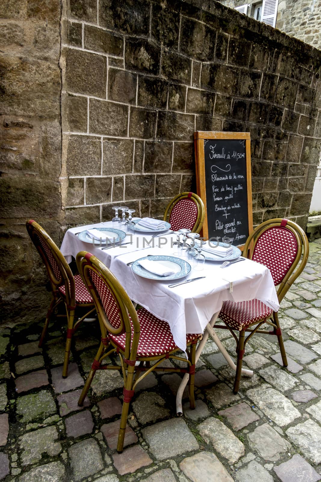Dining table in front of the french medieval buildings by Tetyana