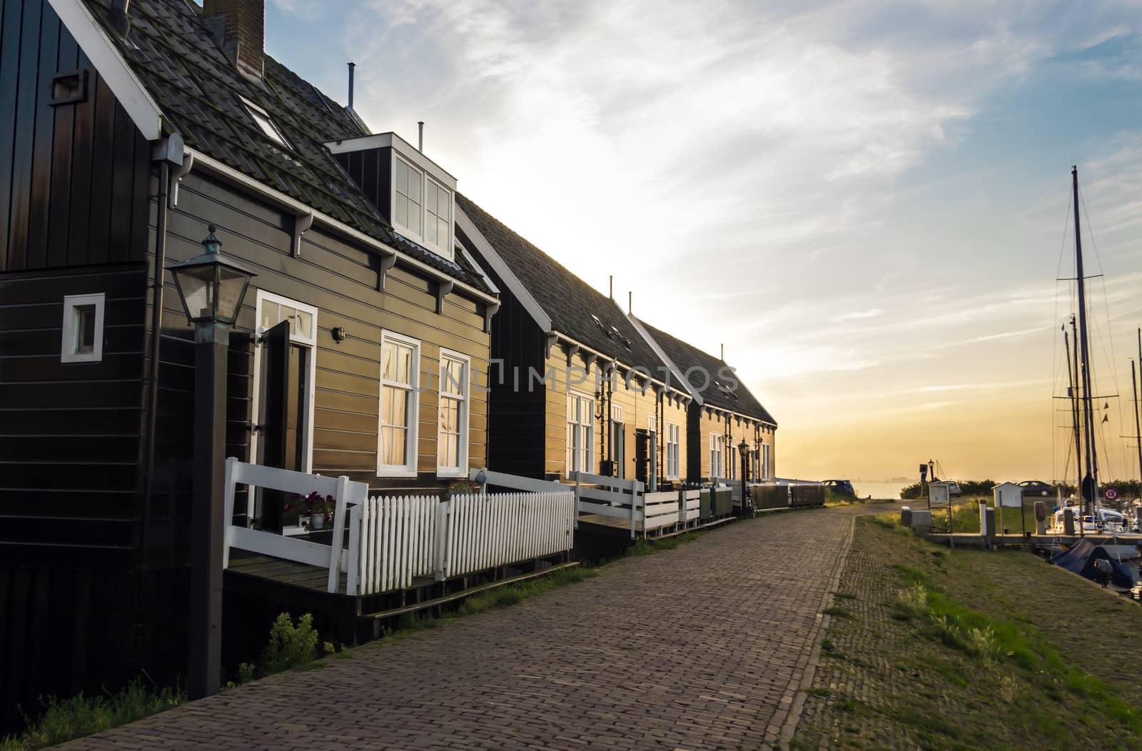 Holland, Volendam village, typical old dutch houses into the sun by Tetyana