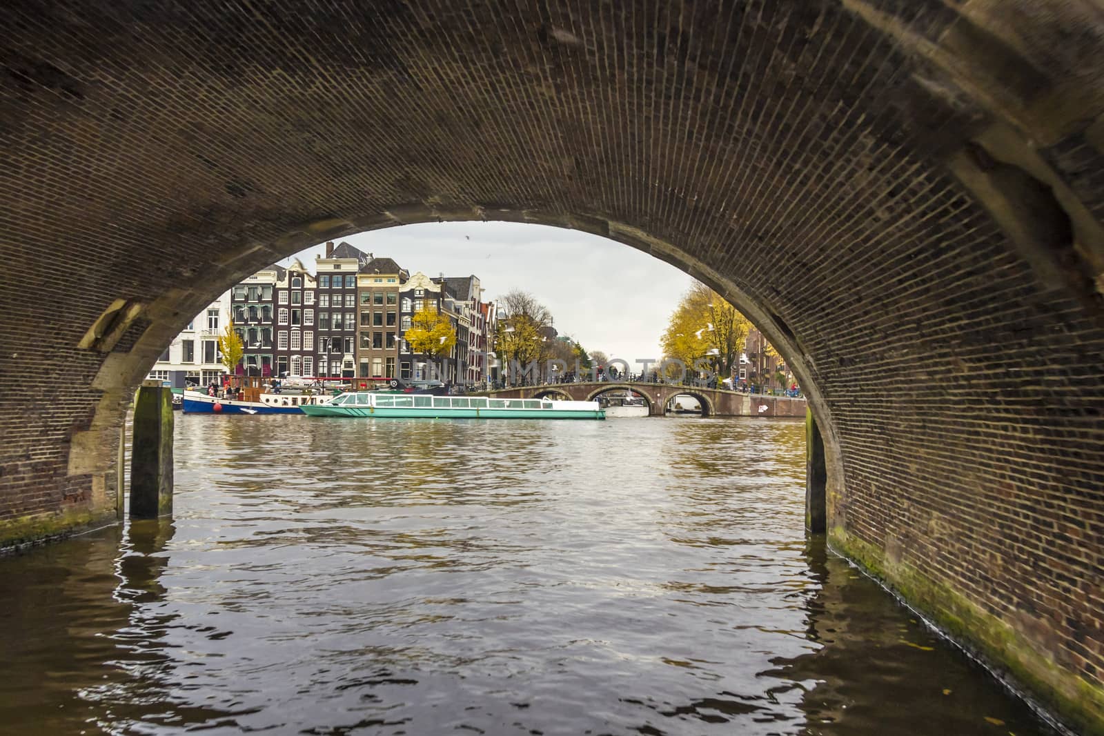 View from under bridge to Amsterdam  in the late autumn, Amstel river
