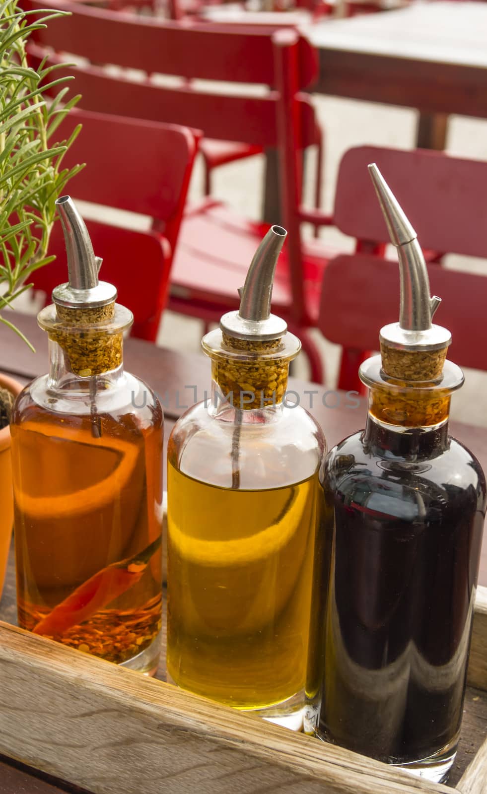 balsamic vinegar bottles and condiments on the table in an open  by Tetyana