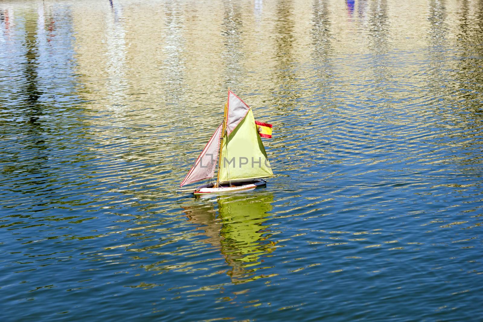 Traditional small wooden sailing boat in the pond of park Jardin by Tetyana