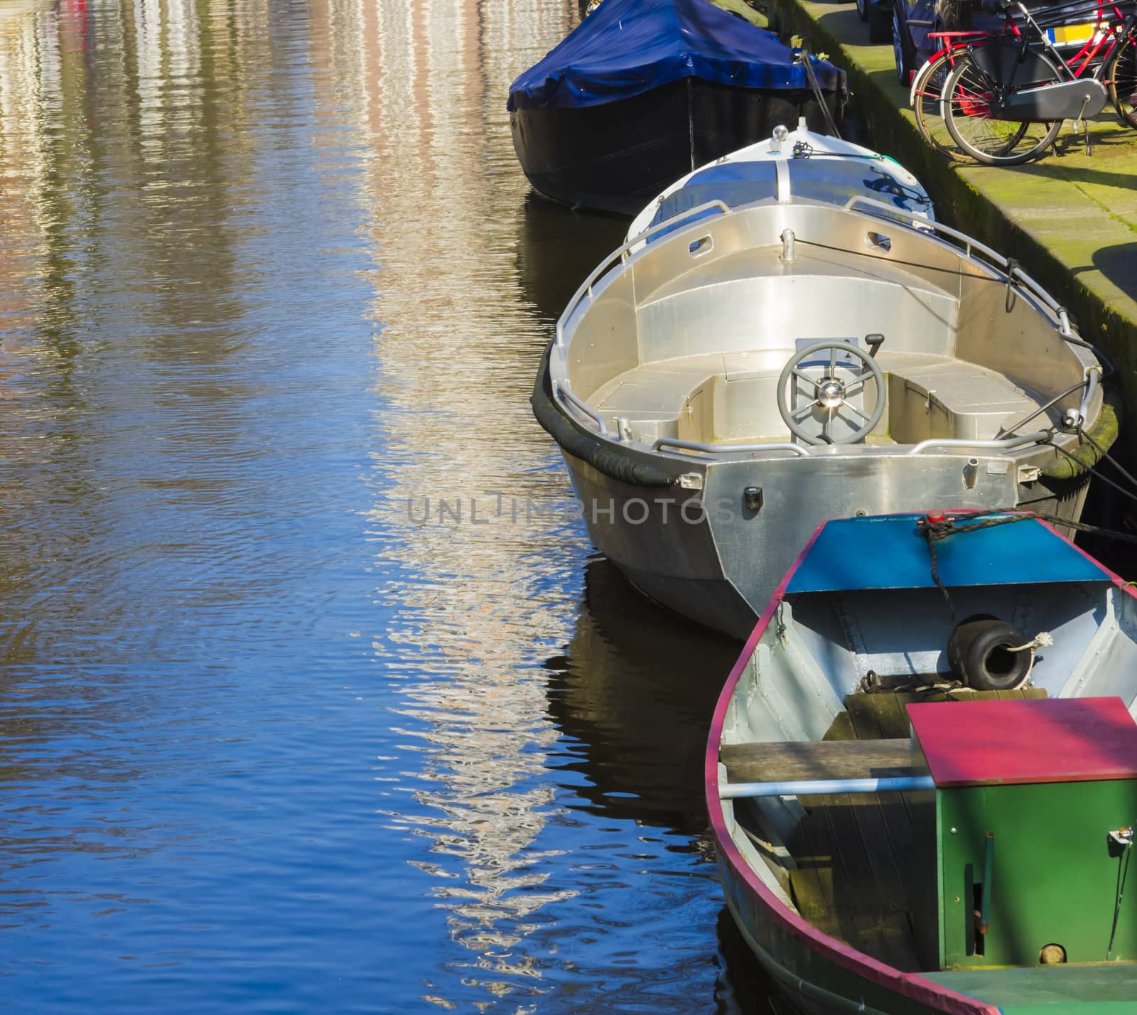 Modern boats on the canal of Amsterdam by Tetyana