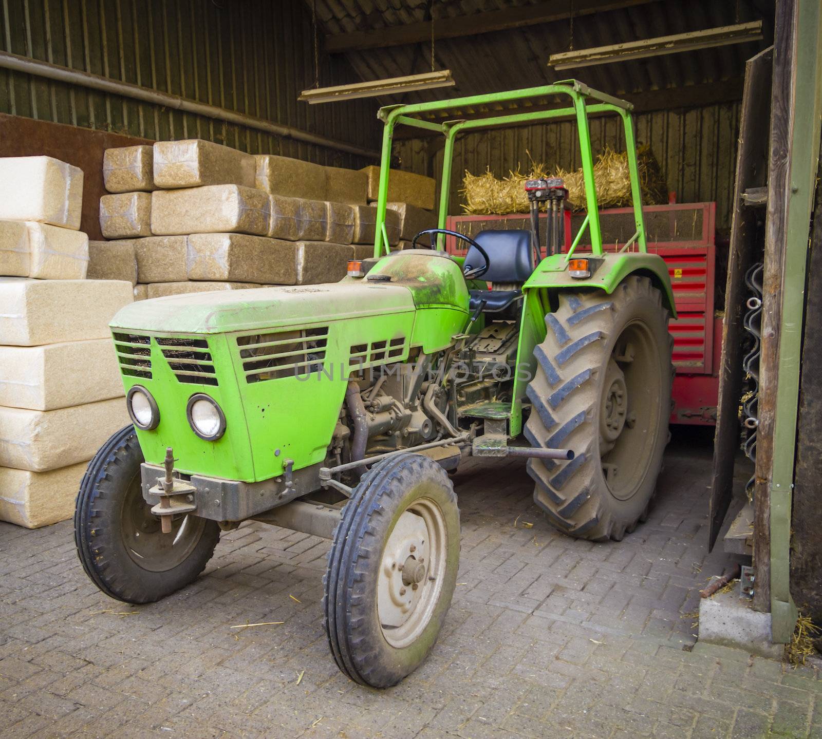 Green tractor sheltered against the background of packages with  by Tetyana