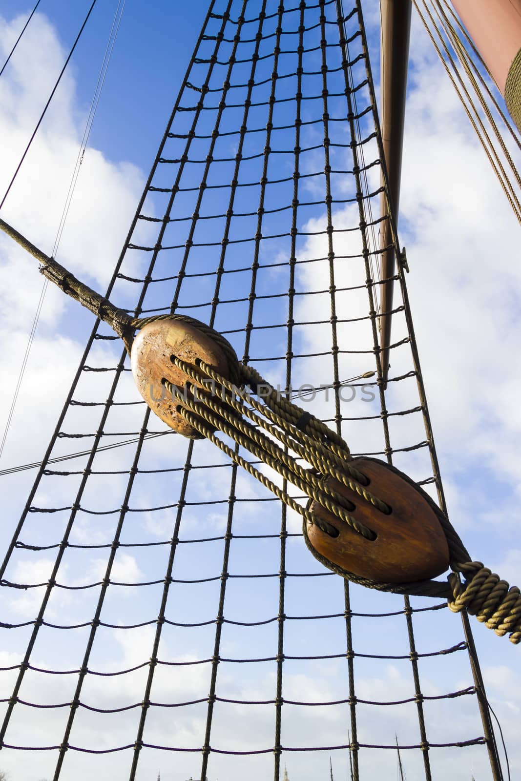 Marine rope ladder at ship. Ladder upstairs on the mast against blue sky.