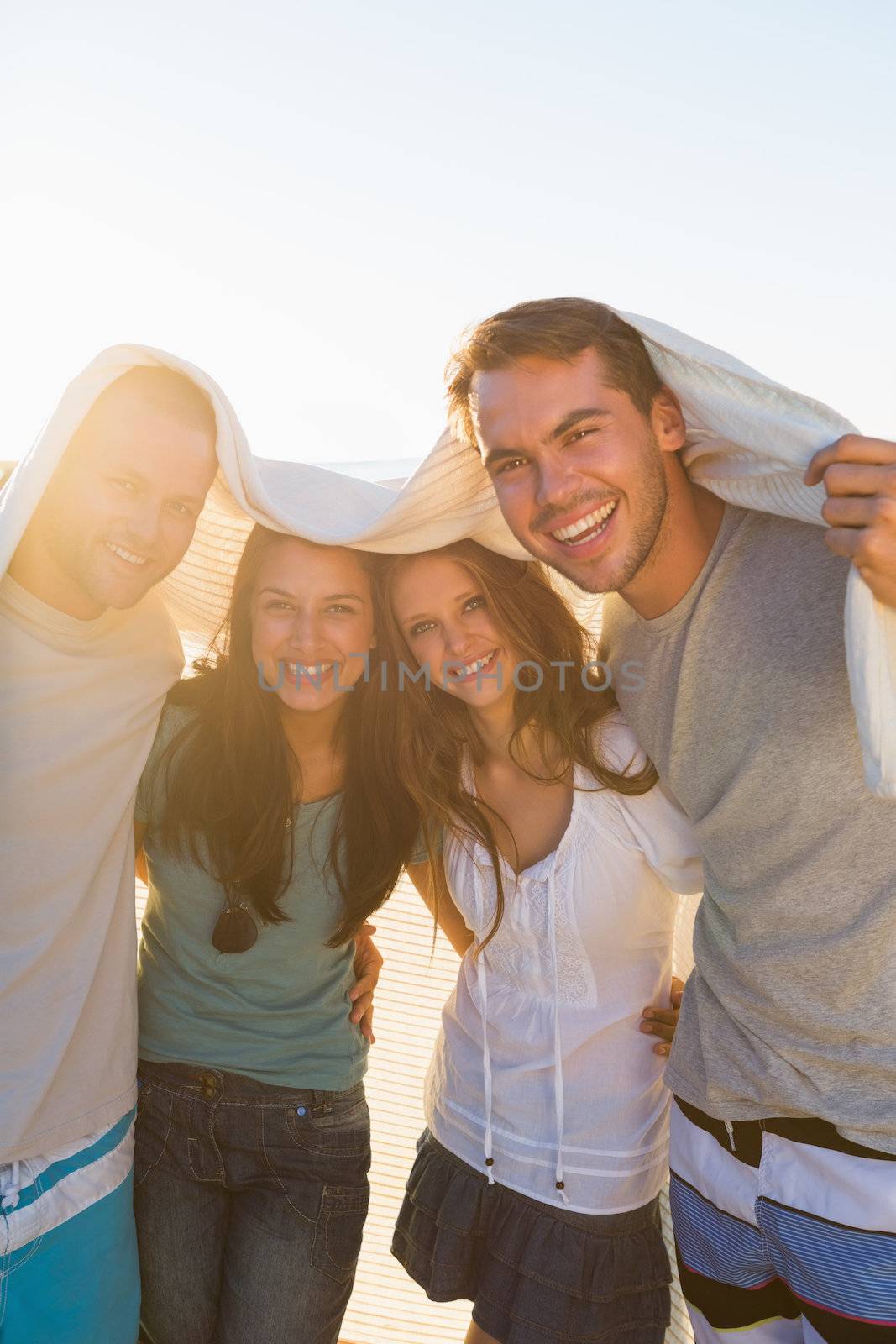 Joyful group of friends having fun together on the beach