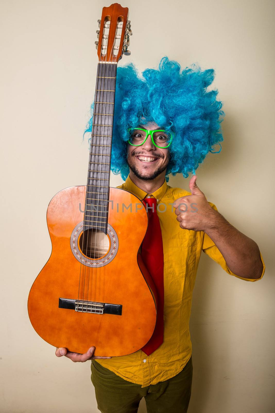 crazy funny young man with blue wig on white background