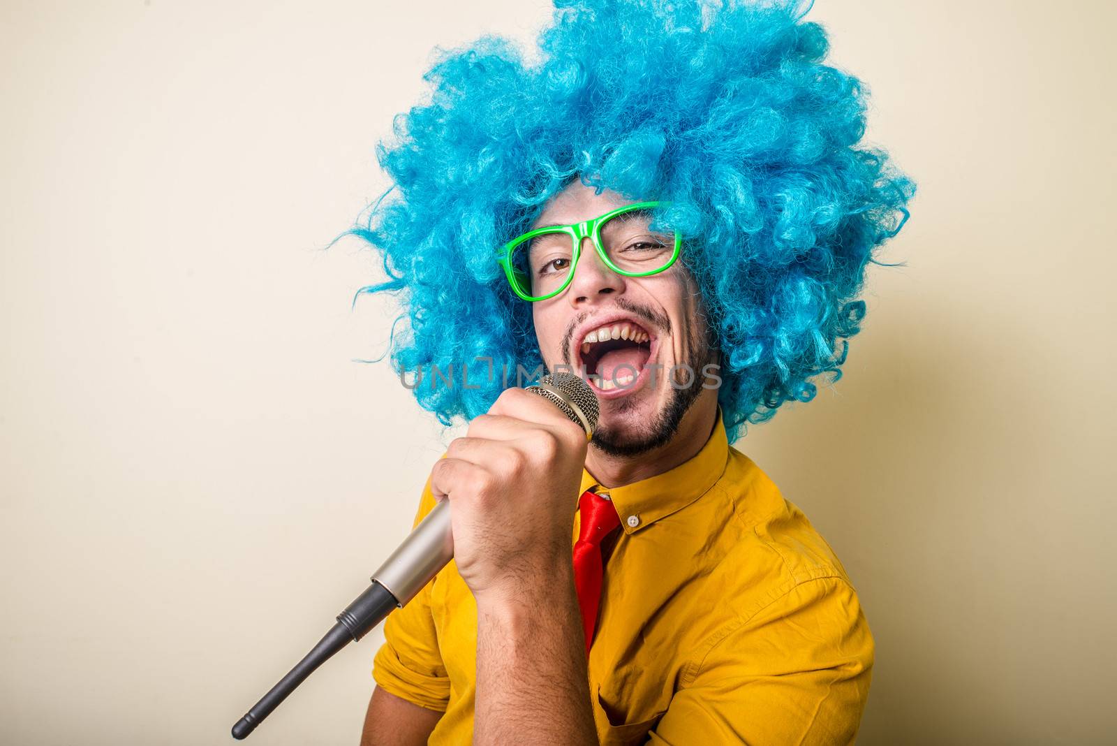 crazy funny young man with blue wig on white background