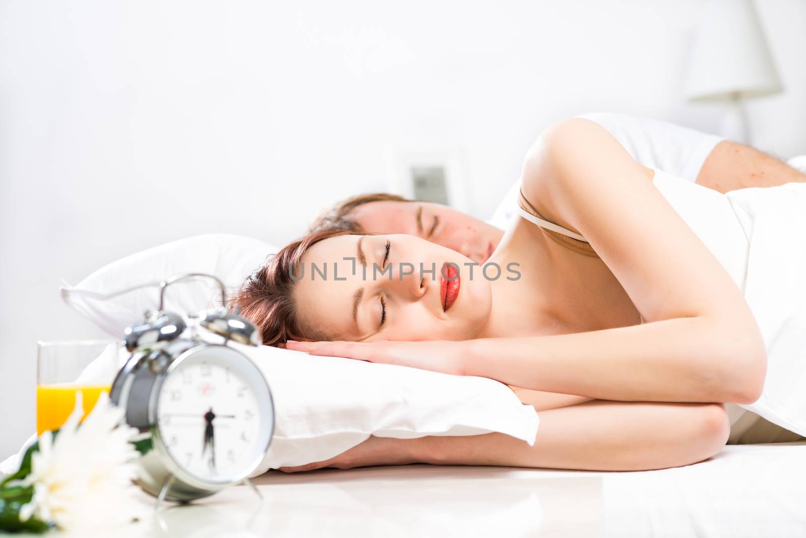 young beautiful woman sleeping on the bed with her husband