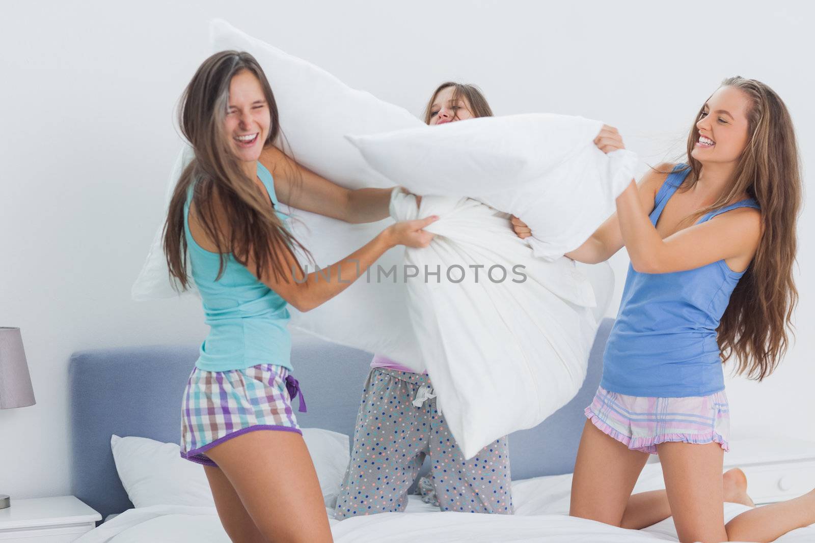 Friends having pillow fight by Wavebreakmedia