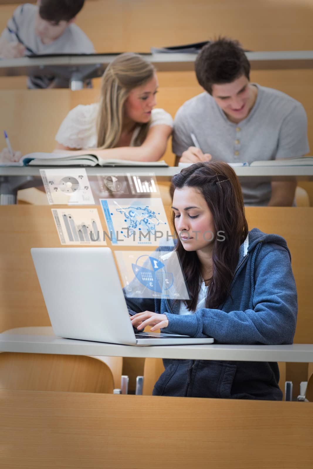 Pretty brunette studying on her digital laptop in lecture hall