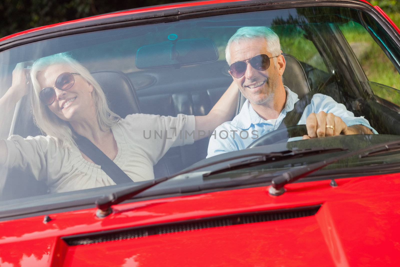 Happy mature couple in red cabriolet by Wavebreakmedia