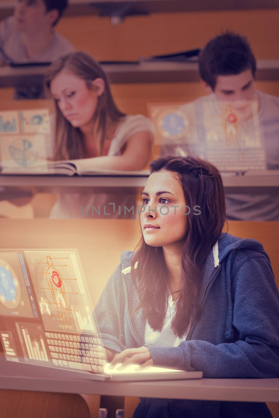 Concentrated pretty student working on her futuristic laptop in lecture hall