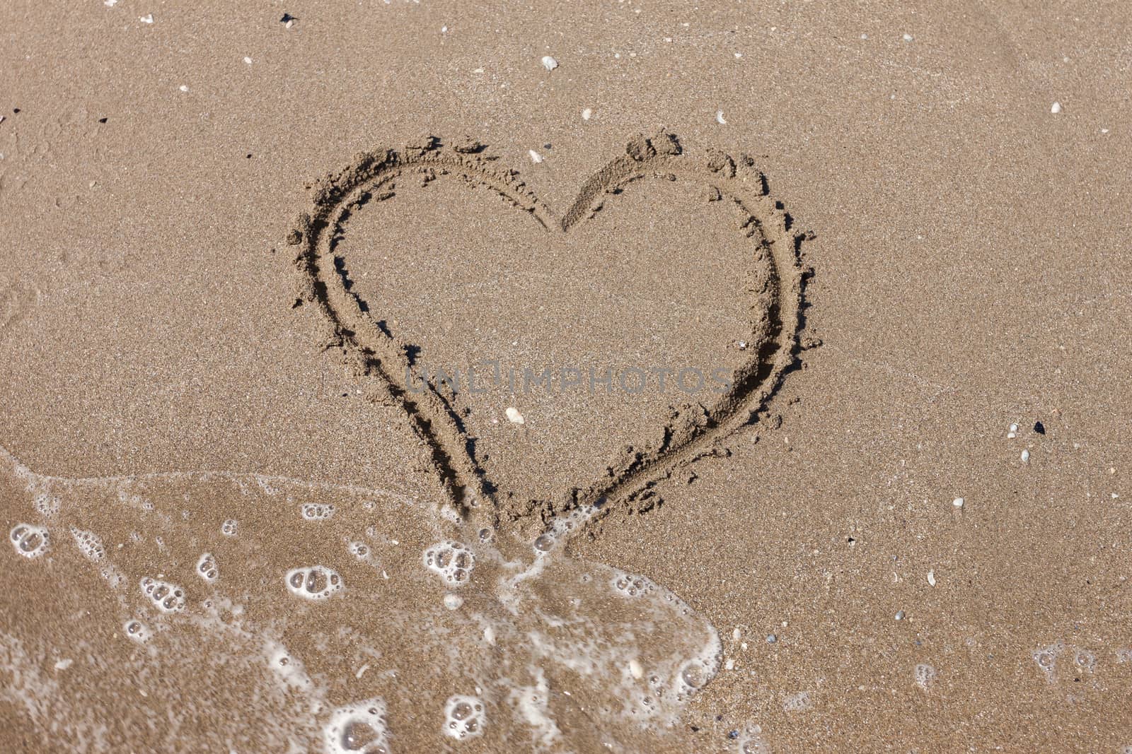 Heart on the sandy beach. Romantic composition.