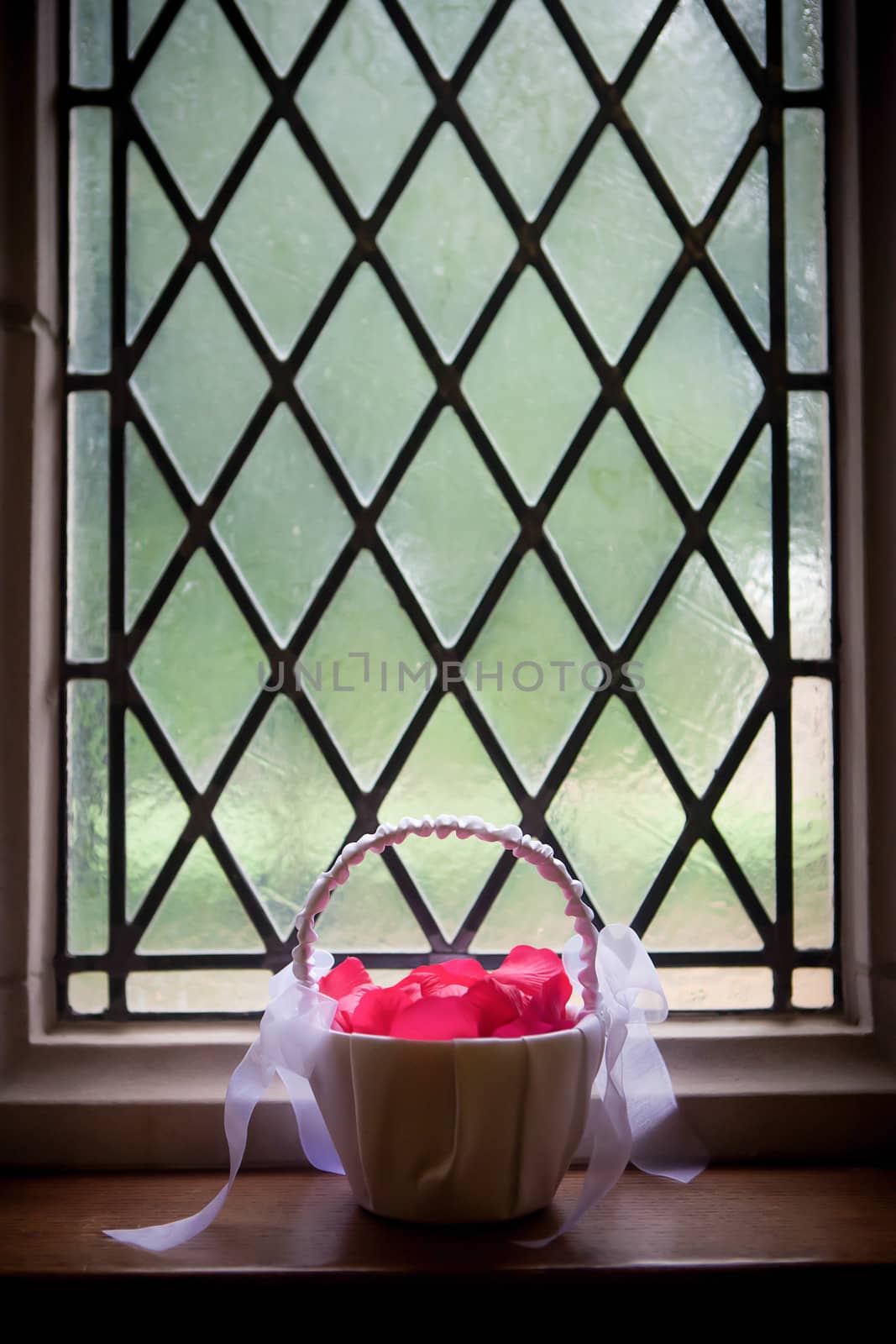 Rose Petals in Basket sitting on a window ledge.